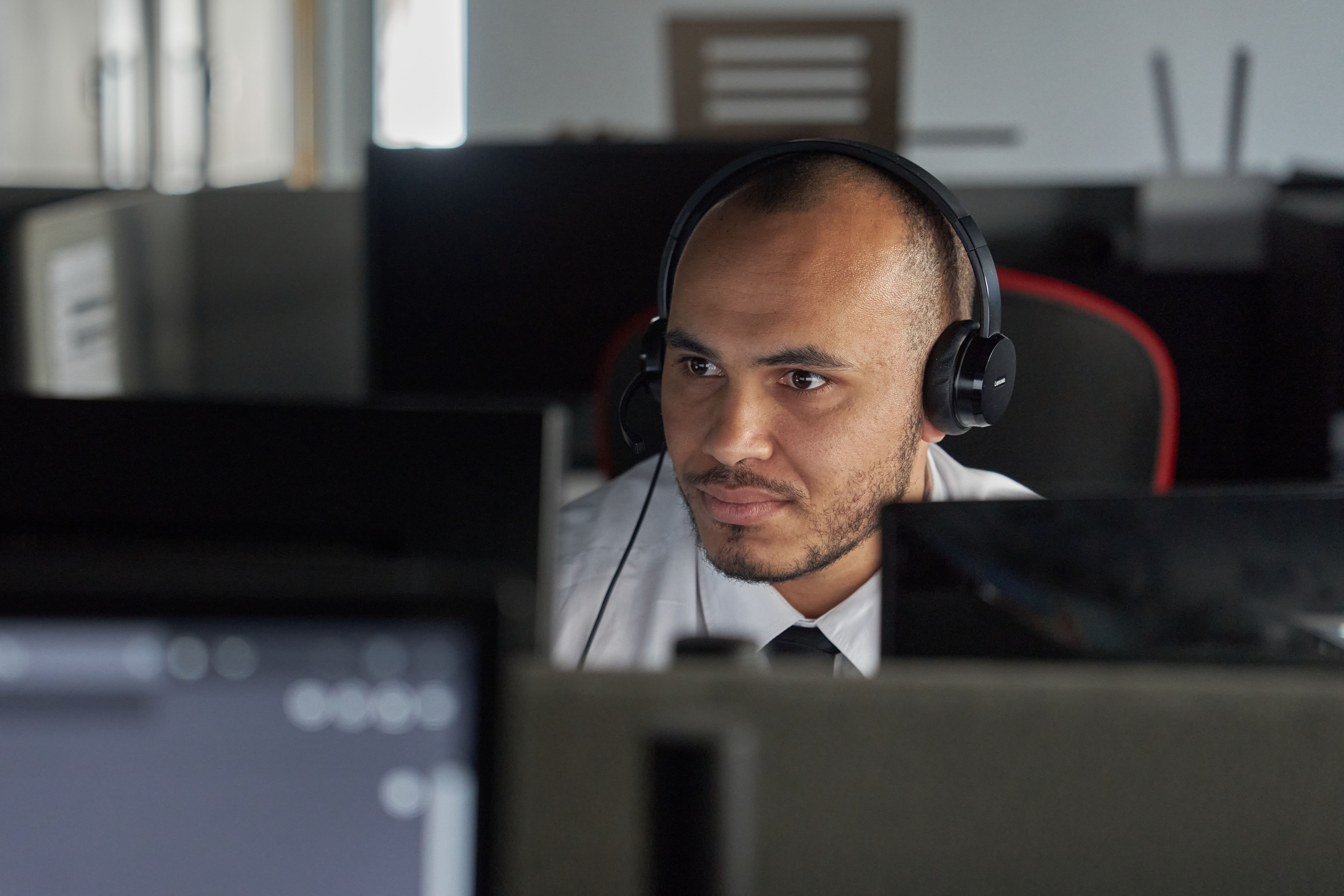 man with headphones is looking at his laptop.