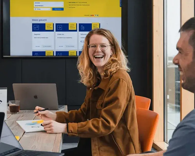 Colleagues laughing with each other during meeting.