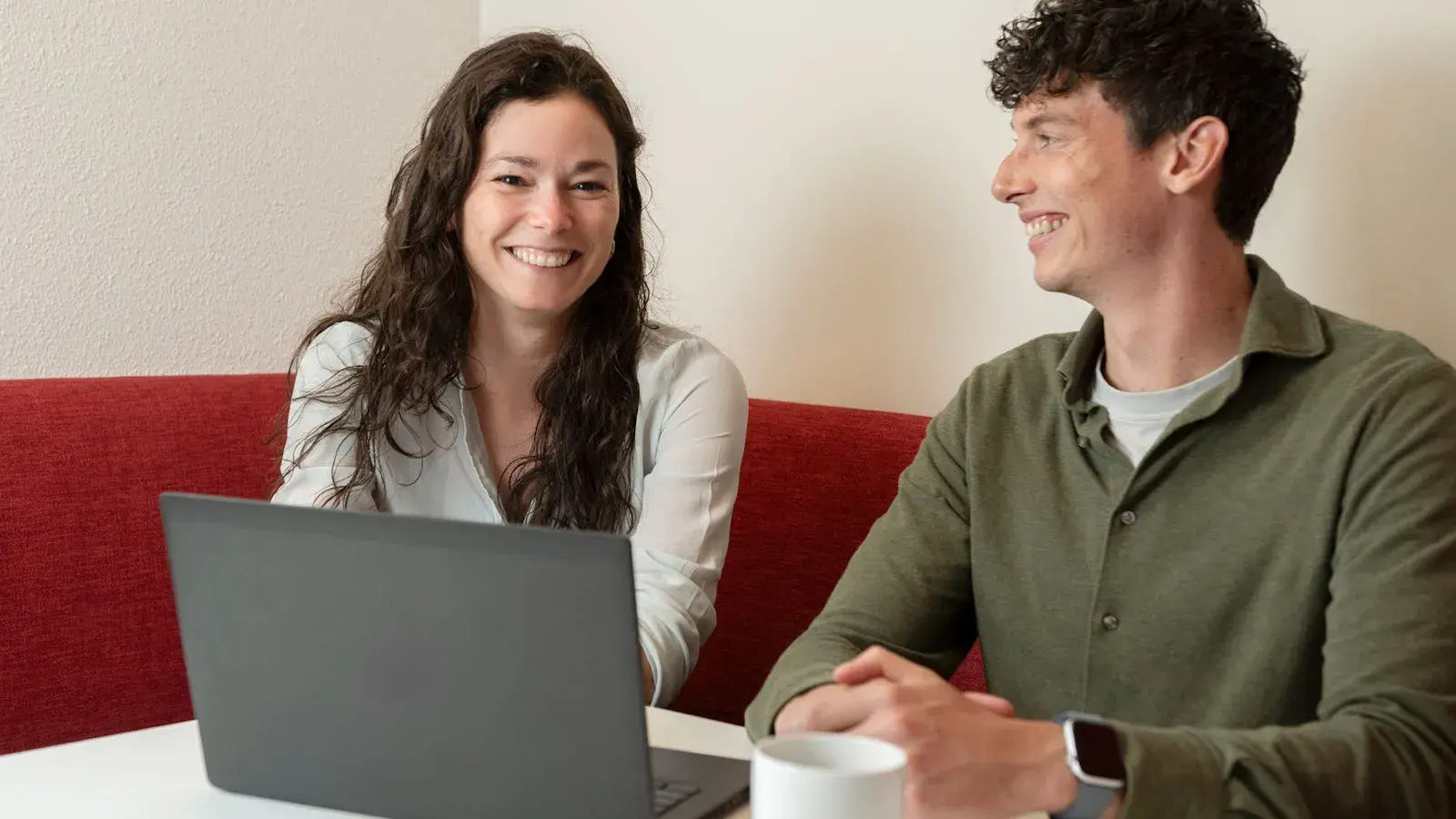 Jonge vrouw en man achter laptop.