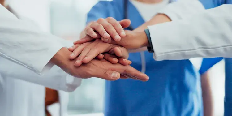 zorgprofessionals met hun handen op elkaar