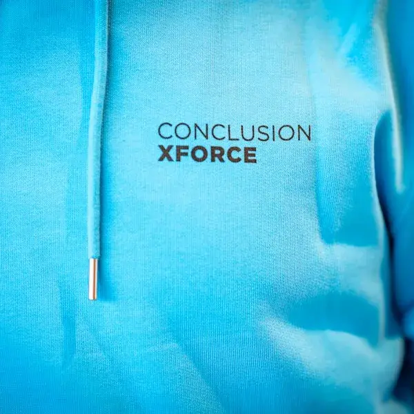 Blauwe trui met Conclusion XForce logo erop.