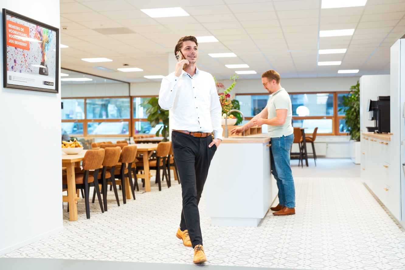 man walking in office while being on the phone