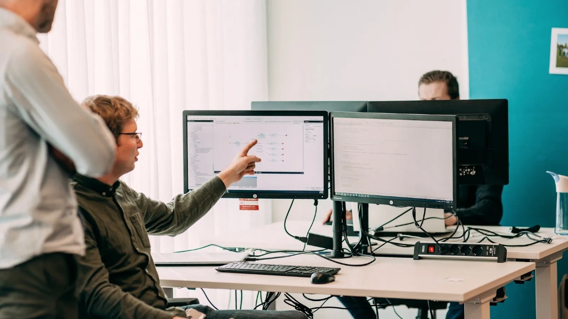 Mannen in kantoor wijzen naar beeldscherm