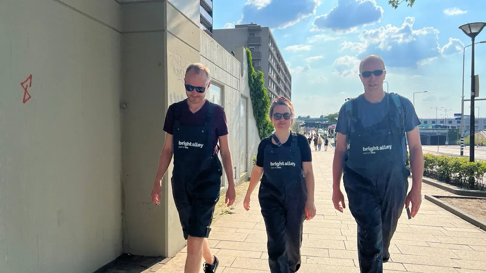 Drie bright alley collegas lopen buiten