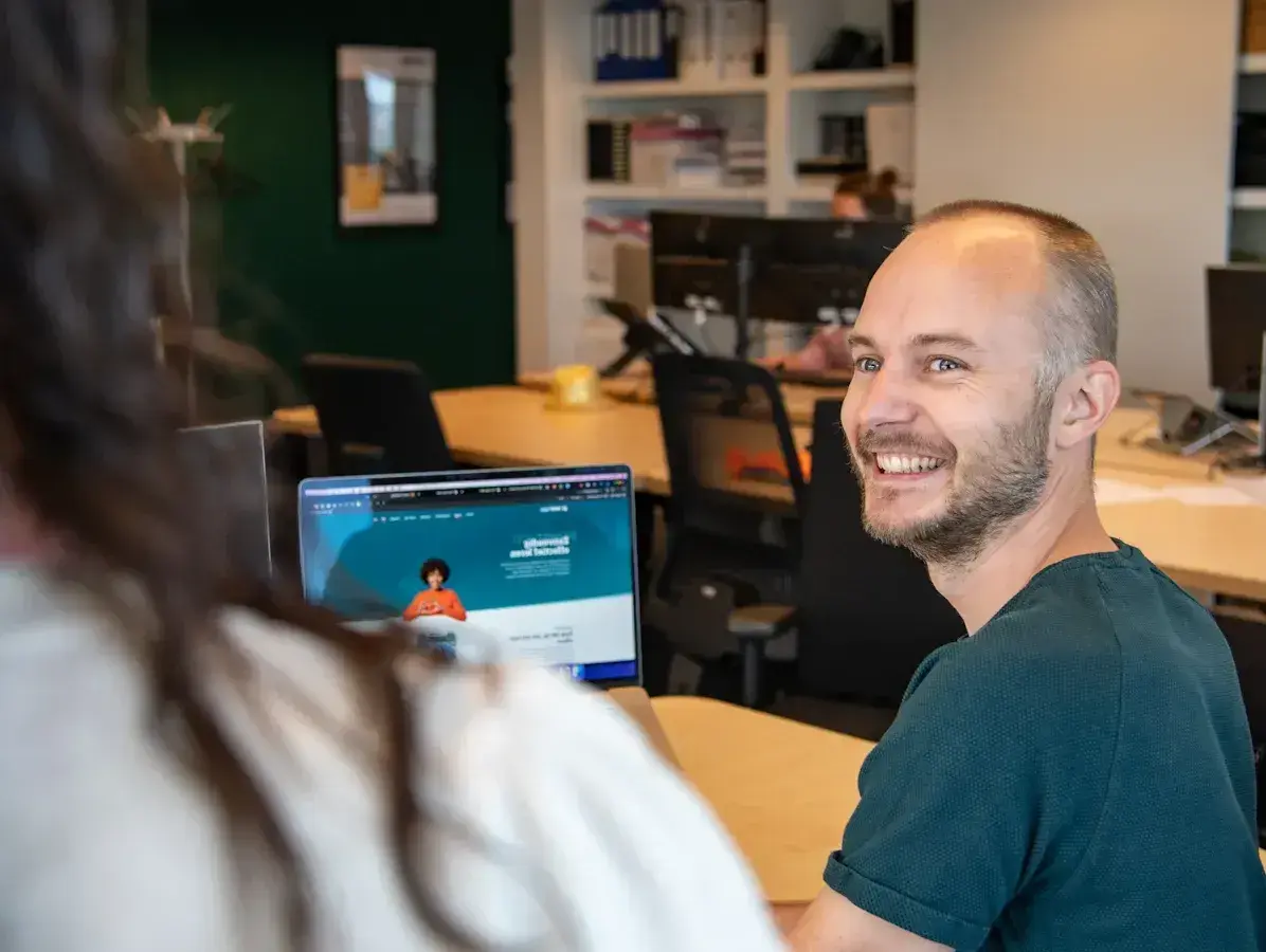 Een man kijkt lachend naar zijn collega-1-1