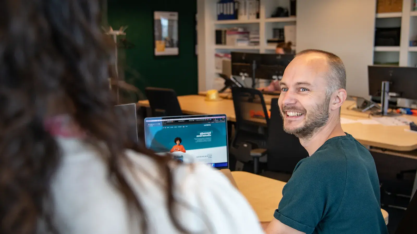 Een man kijkt lachend naar zijn collega