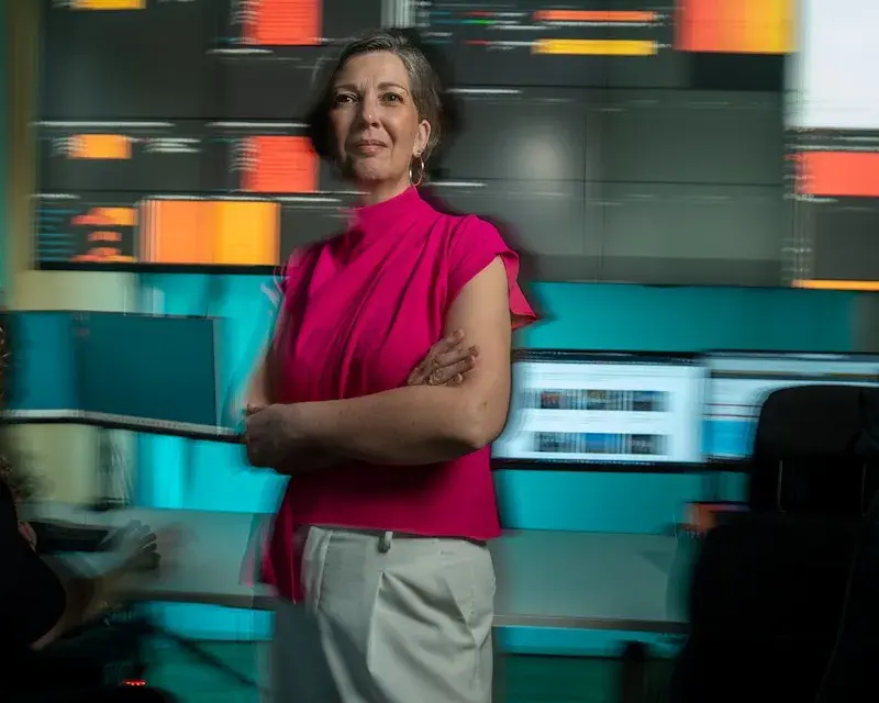 Een mevrouw staat voor een paar schermen