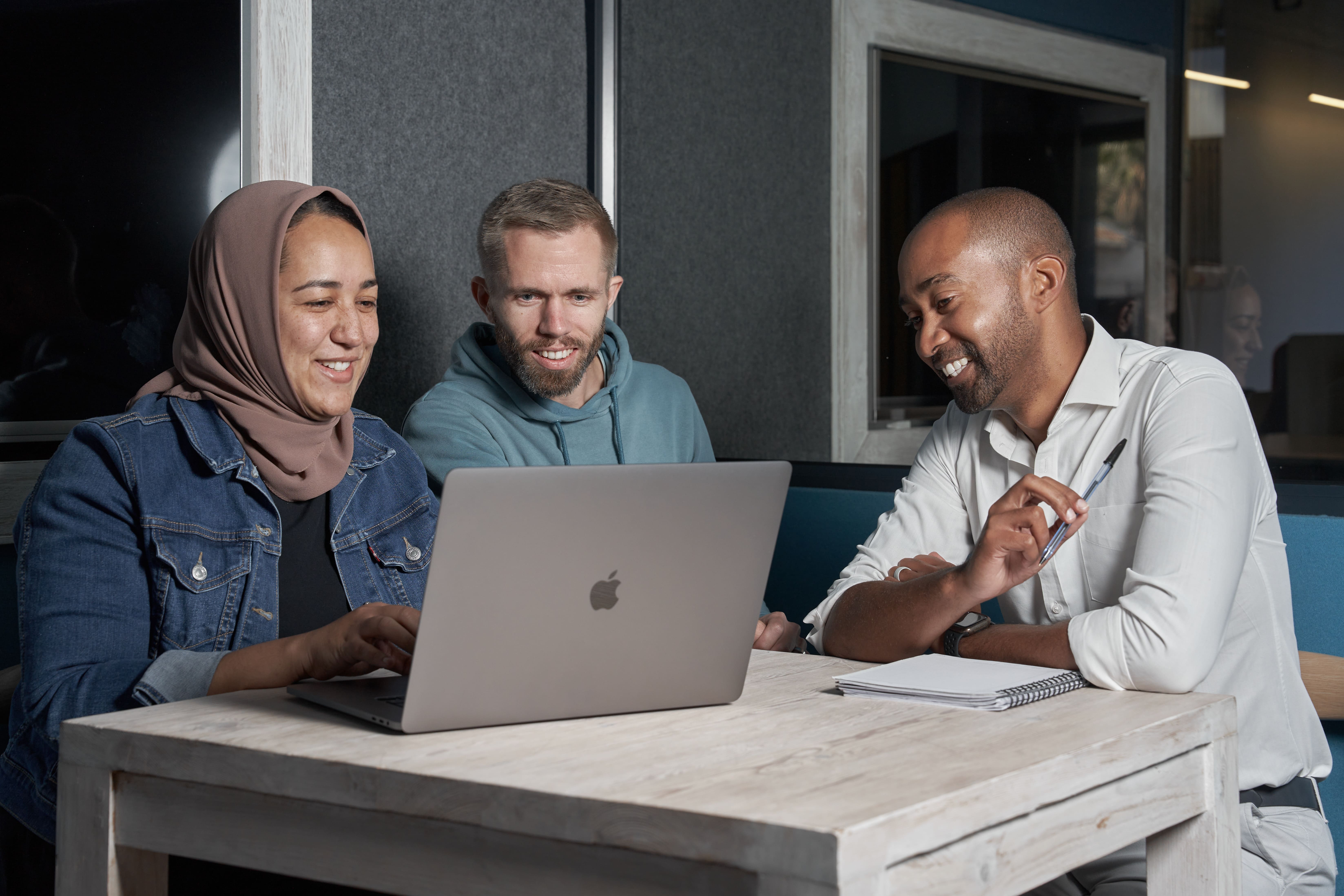 Three people looking at a laptop screen