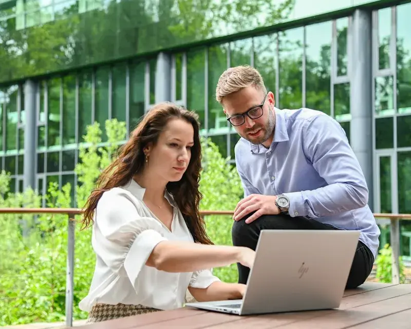 Twee collegas werken met een laptop