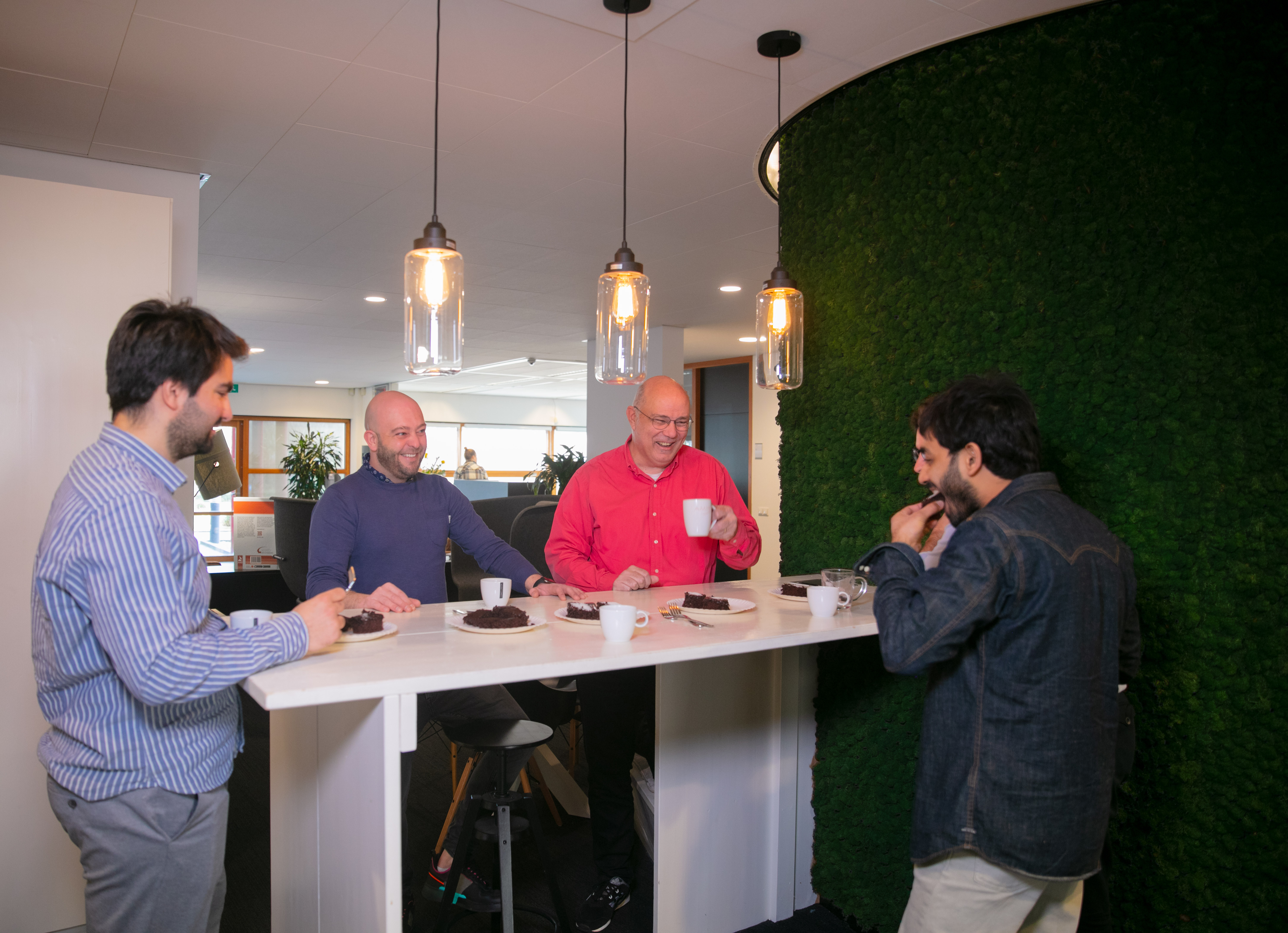 Men sitting at a table eating cake